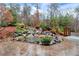 An outdoor patio features a scenic pond with natural rock waterfall and professionally landscaped trees and shrubs at 2691 Jamerson Rd, Marietta, GA 30066