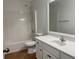 A bright bathroom showcases a white vanity, framed mirror, and a shower-tub combination at 868 Still Hill Ln, Lawrenceville, GA 30045