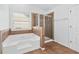 Bathroom with a large soaking tub, glass shower, and tile flooring at 868 Still Hill Ln, Lawrenceville, GA 30045