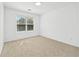 Bright, carpeted bedroom with a window providing natural light at 868 Still Hill Ln, Lawrenceville, GA 30045
