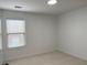 A serene bedroom offers plush carpeting, a large window with blinds, and fresh white walls and trim at 868 Still Hill Ln, Lawrenceville, GA 30045
