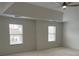 Bedroom with neutral carpet, tray ceiling, crown molding, and two large windows at 868 Still Hill Ln, Lawrenceville, GA 30045