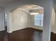 Elegant dining room featuring dark wood floors, arched doorway, wainscoting and modern chandelier at 868 Still Hill Ln, Lawrenceville, GA 30045