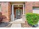 Home's front entrance features brick and stone columns and a glass front door at 868 Still Hill Ln, Lawrenceville, GA 30045