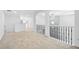 Upstairs hallway with neutral carpeting, black metal railings, and modern lighting at 868 Still Hill Ln, Lawrenceville, GA 30045