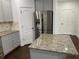 Kitchen showcasing stainless steel refrigerator, granite countertops, and gray cabinets at 868 Still Hill Ln, Lawrenceville, GA 30045