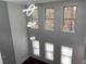 A bright living room featuring tiered chandeliers, large windows with wooded views, and a cozy fireplace at 868 Still Hill Ln, Lawrenceville, GA 30045