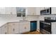 Contemporary kitchen featuring white cabinets, stainless steel appliances, and stone backsplash at 139 Dahlia Nw Ave, Atlanta, GA 30314