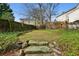 View of the backyard featuring mossy stones, lush greenery, and a wood fence at 2836 Alpine Ne Rd, Atlanta, GA 30305