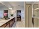 Bathroom with dual sinks, wood cabinets, a vanity, large mirror, shower, and view into the bedroom at 1676 Charcoal Ives Rd, Lawrenceville, GA 30045