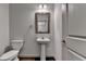 A half-bath with pedestal sink, mirror, and modern fixtures providing a clean and functional space at 1676 Charcoal Ives Rd, Lawrenceville, GA 30045