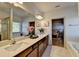 A bathroom features dual sinks, wood cabinets, vanity, large mirror, and a glimpse of the bedroom at 1676 Charcoal Ives Rd, Lawrenceville, GA 30045