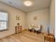 Well-lit bedroom with wood floors, a window, a settee, decor art, and side tables at 1676 Charcoal Ives Rd, Lawrenceville, GA 30045