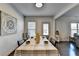 Dining area featuring a long table with seating for six, modern decor, and hardwood floors at 1676 Charcoal Ives Rd, Lawrenceville, GA 30045