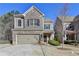 Charming two-story home featuring a brick facade, attached garage, and manicured lawn at 1676 Charcoal Ives Rd, Lawrenceville, GA 30045