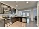 A modern kitchen with stainless steel appliances, dark cabinets, granite countertops, and dining area in view at 1676 Charcoal Ives Rd, Lawrenceville, GA 30045