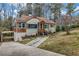 Charming home with tan siding, brown accents, landscaped yard, and driveway leading to a covered parking area at 1747 Parkhill Dr, Decatur, GA 30032