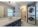 Bathroom featuring a sink with vanity, shower, and stacked washer and dryer units at 1958 Starfire Ne Dr, Atlanta, GA 30345