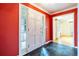 Bright foyer with a red accent wall, black slate floors and a white front door with side windows at 1958 Starfire Ne Dr, Atlanta, GA 30345