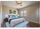 Staged main bedroom boasts wood floors, ceiling fan, closet, and a bright window view at 2102 Lenoa Ln, Austell, GA 30106