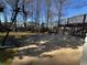 Backyard with a basketball court leading to a two story deck, with shed in the distance, surrounded by trees at 6542 Cherry Tree Ln, Atlanta, GA 30328