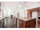 Open-concept kitchen featuring dark wood cabinets, an island, and views into the living area at 11330 Easthaven Pl, Johns Creek, GA 30097