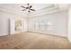 A carpeted main bedroom featuring trey ceiling, ceiling fan, and an ensuite bath at 11330 Easthaven Pl, Johns Creek, GA 30097