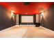 A cozy media room with a projector screen, neutral carpet, and dark gray walls with a red ceiling at 11330 Easthaven Pl, Johns Creek, GA 30097