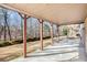 A covered concrete patio with wooden posts offers ample shade and views to the backyard at 11330 Easthaven Pl, Johns Creek, GA 30097