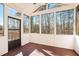 Bright sunroom with wood flooring, large windows, and views of the wooded backyard at 11330 Easthaven Pl, Johns Creek, GA 30097