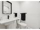 Modern bathroom with sleek fixtures, pedestal sink, and a classic black and white patterned floor at 1406 Winston Pl, Decatur, GA 30033