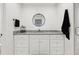 Modern bathroom with white vanity, granite countertop, round mirror, and black towel at 1406 Winston Pl, Decatur, GA 30033