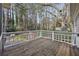 View of the wooden deck with a white railing overlooking a lush, wooded backyard at 1406 Winston Pl, Decatur, GA 30033