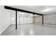 Spacious garage with gray flooring, a white door, and industrial-style support beams at 1406 Winston Pl, Decatur, GA 30033