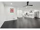 Open-concept space with dark hardwood floors, white walls, and a modern kitchen in the background at 1406 Winston Pl, Decatur, GA 30033