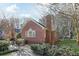 Side view of brick home with tidy landscaping, chimney, and mature trees at 1406 Winston Pl, Decatur, GA 30033