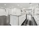 Kitchen island with granite countertop, white cabinets, stainless steel appliances, and dark hardwood floors at 1406 Winston Pl, Decatur, GA 30033