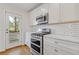 Bright kitchen features white cabinetry, stainless steel appliances, and a gas range at 1824 Westwood Sw Ave, Atlanta, GA 30310