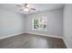 Bright bedroom featuring hardwood floors, modern ceiling fan and window with lovely outdoor view at 4335 Hastings Dr, Cumming, GA 30041