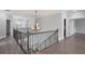 Hallway landing with decorative chandelier and iron railing at 4335 Hastings Dr, Cumming, GA 30041