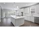 Bright kitchen with white cabinets, stainless steel appliances, and an island, flowing into a sunny dining area at 4335 Hastings Dr, Cumming, GA 30041