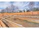 A sloped backyard featuring a wooden retaining wall and a wood fence at 965 Mulberry Bay Dr, Dacula, GA 30019