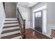 Welcoming foyer with hardwood floors, staircase with decorative iron railing, and natural light creates a grand entrance at 965 Mulberry Bay Dr, Dacula, GA 30019