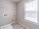 Small laundry room with tile floor, shelving, utility connections and a window at 965 Mulberry Bay Dr, Dacula, GA 30019