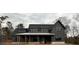 Modern farmhouse-style home with board and batten siding, stone accents, and a welcoming covered front porch at 157 Palisade Dr, Rydal, GA 30171