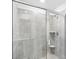 Modern tiled shower featuring glass enclosure, rainfall shower head, and built-in corner shelving at 2778 Aralynn Way, College Park, GA 30337