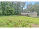 A shot of the large backyard with tall trees and green grass behind the house at 467 Pineburr Ln, Stone Mountain, GA 30087