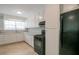Well-lit kitchen equipped with black appliances, ample cabinet space and tile flooring at 467 Pineburr Ln, Stone Mountain, GA 30087
