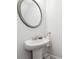Charming pedestal sink in a bathroom with a decorative oval mirror at 642 Stickley Oak Way, Woodstock, GA 30189