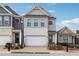 Charming two-story home with gray siding, a white brick facade, and a two-car garage with a brick paver driveway at 642 Stickley Oak Way, Woodstock, GA 30189